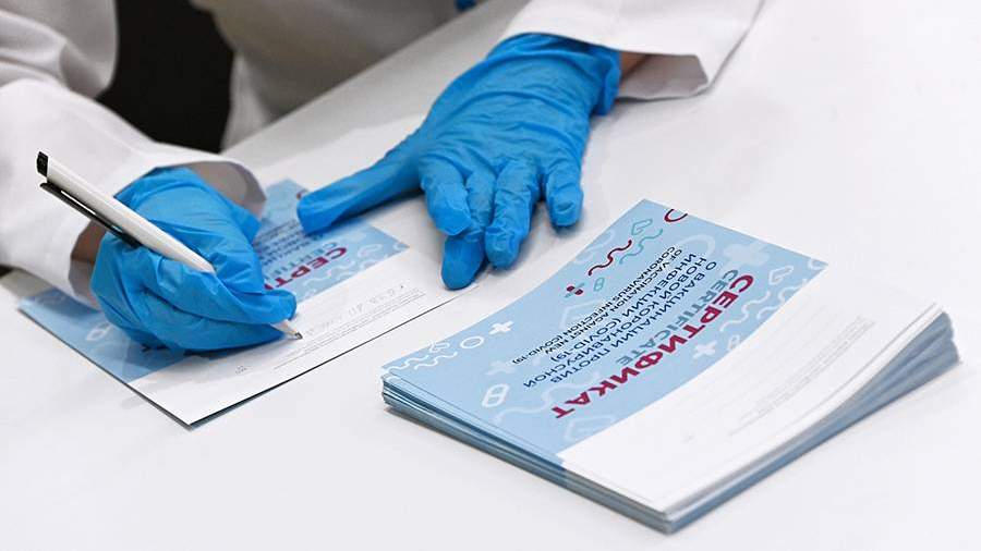 Медицинский сотрудник подписывает сертификат в центре вакцинации от COVID-19