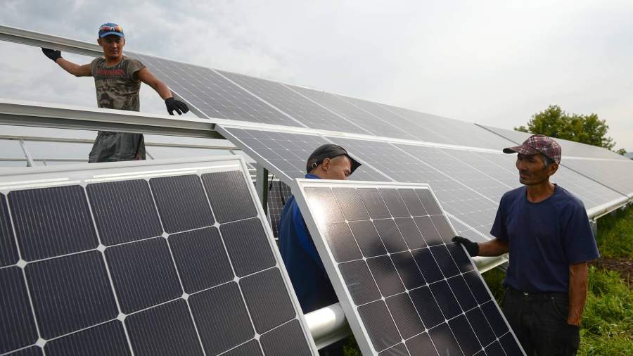 рабочие монтируют солнечные батареи