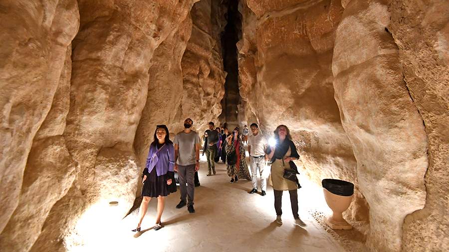 Туристы в пещере в горе Аль-Агра недалеко от города Эль-Хаса в Саудовской Аравии