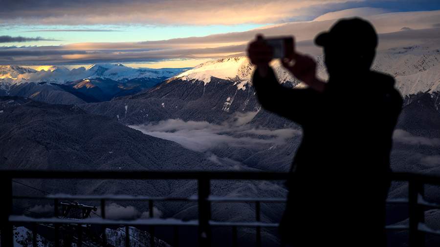Мужчина фотографирует горы на горнолыжном курорте