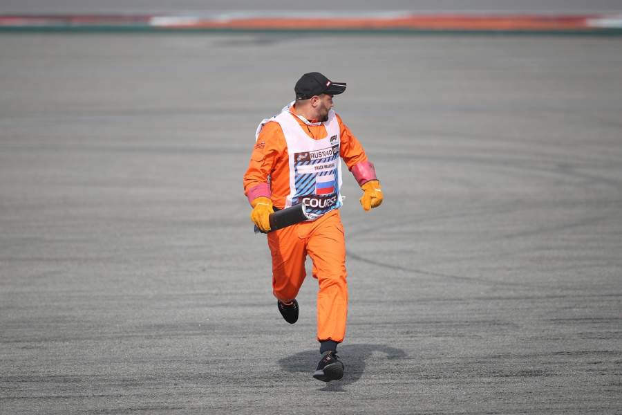 Маршал убирает обломки с трассы во время гонки на российском этапе чемпионата мира по кольцевым автогонкам в классе «Формула-1»