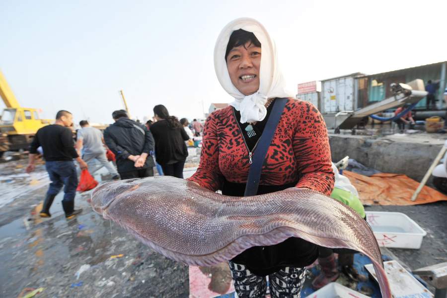 женщина держит в руках огромную рыбу