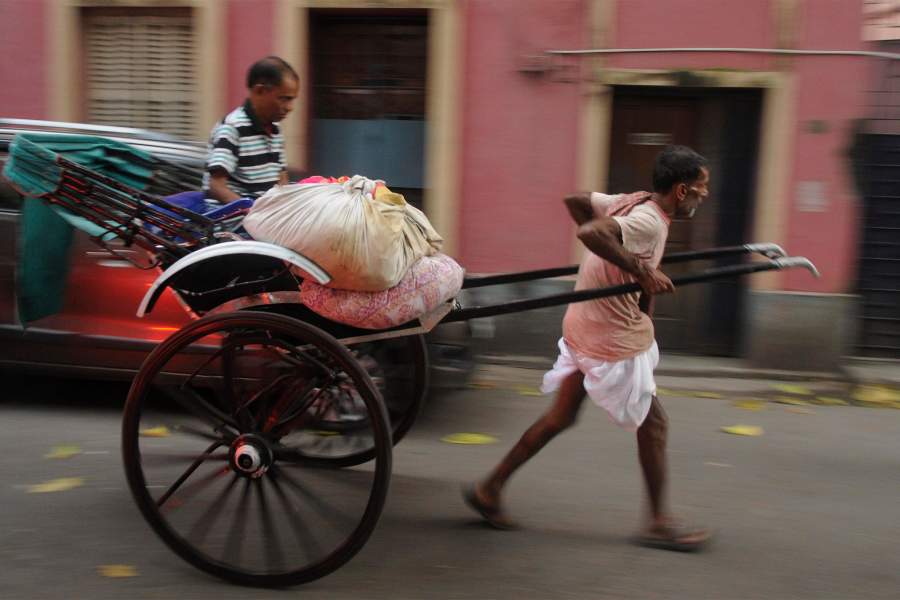 Рикша везет несет выстиранную одежду клиентам