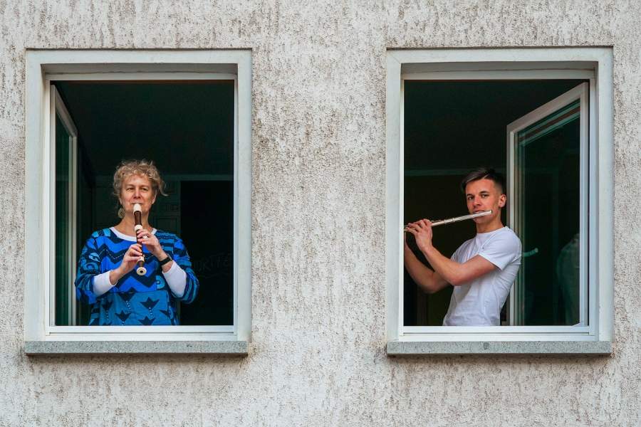 Люди играют на музыкальных инструментах на балконах в Германии