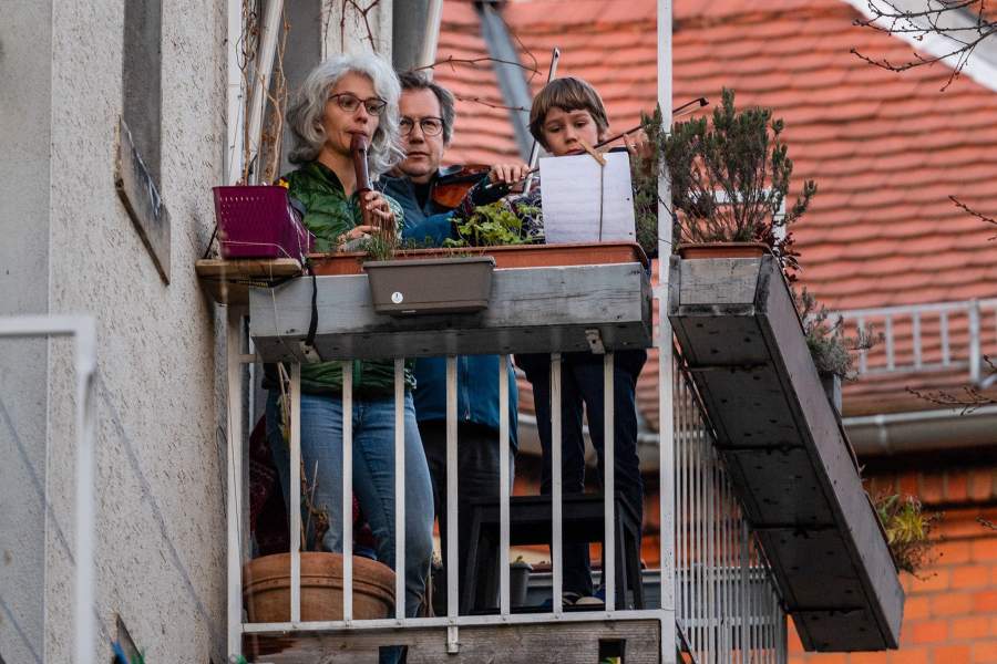 Люди играют на музыкальных инструментах на балконах в Германии