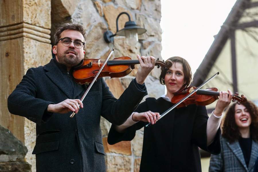 Люди играют на музыкальных инструментах на балконах в Германии