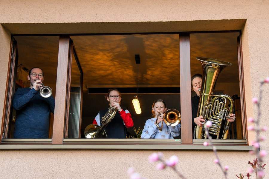 Люди играют на музыкальных инструментах на балконах в Германии