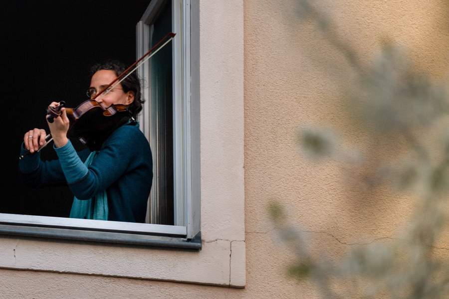 Люди играют на музыкальных инструментах на балконах в Германии