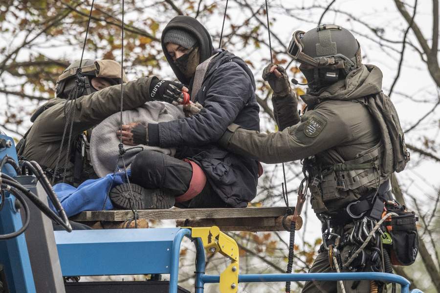 Полицейские снимают с дерева протестующего