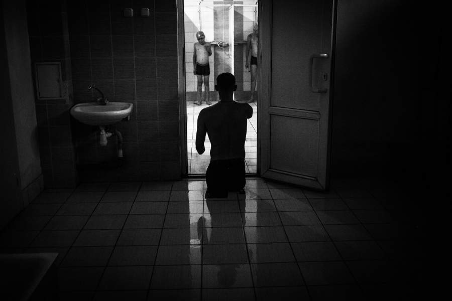 Алексей входит в душевую перед началом тренировки в бассейне