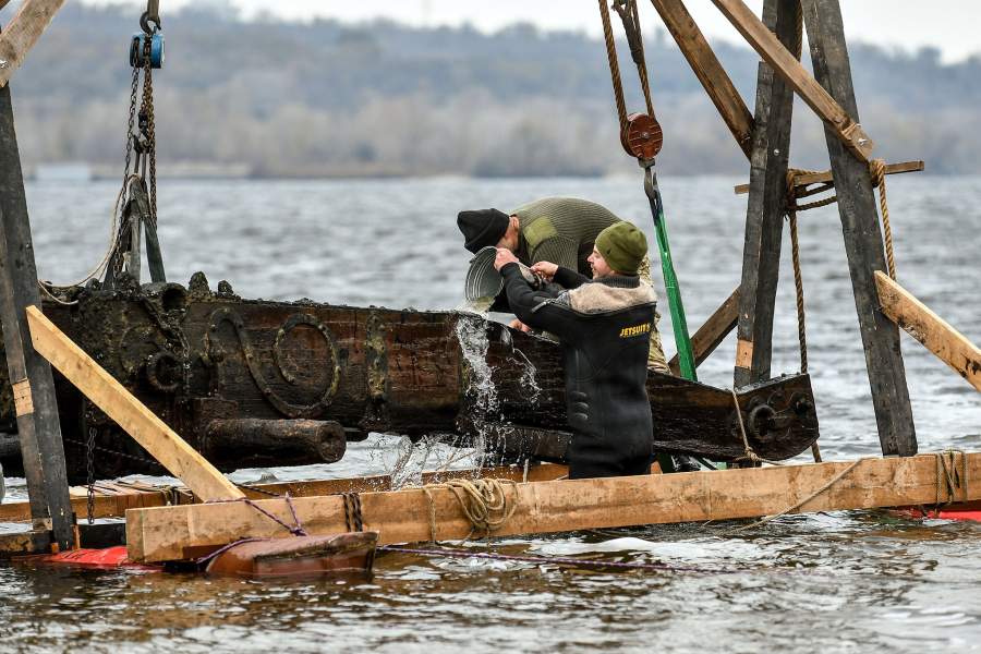 Люди выливают ведро воды на лафет.