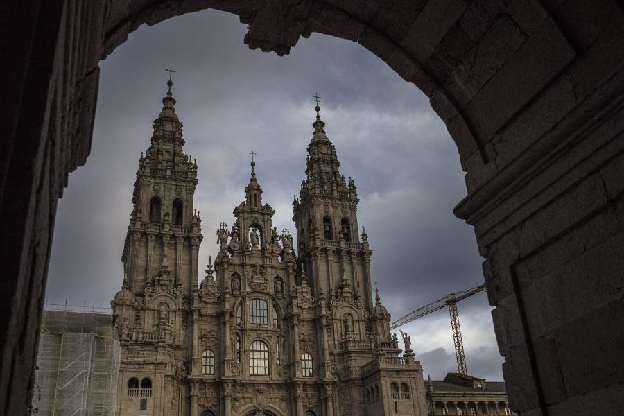 Собор Сантьяго-де-Кампостела виден сквозь средневековые арки 26 ноября 2020 года в Сантьяго-де-Кампостела, Галисия, Испания.