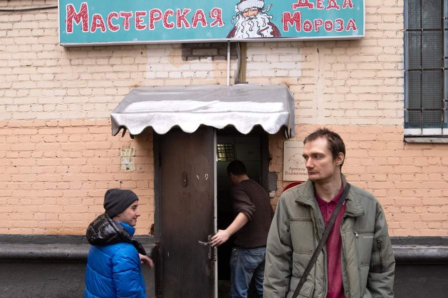Люди возле входа на производственное предприятие для людей с ментальной инвалидностью "Артель блаженных" в Москве.