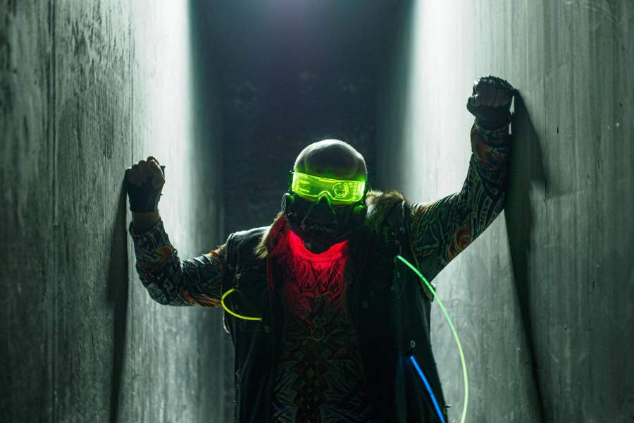 Брутальный мужчина в темном коридоре на фестивале Cyberpunk