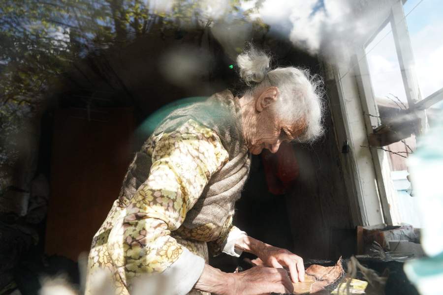 Пожилая женщина 87-лет, живущая в селе Жажлево Заволжского района Ивановской области, вручную изготавливает тапочки