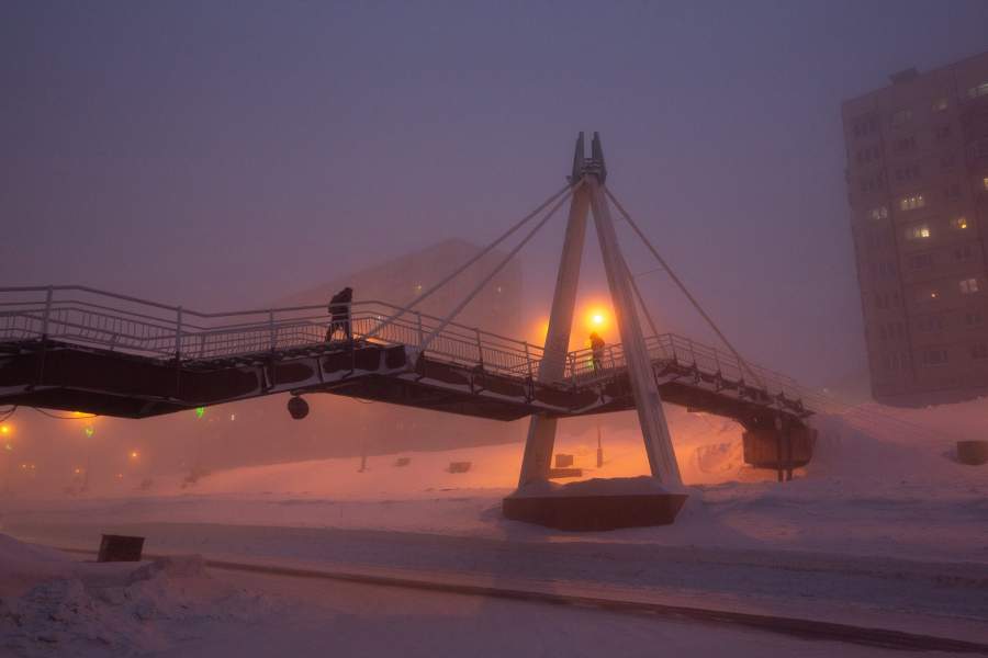 Пешеходный мост через заснеженную дорогу в Норильске