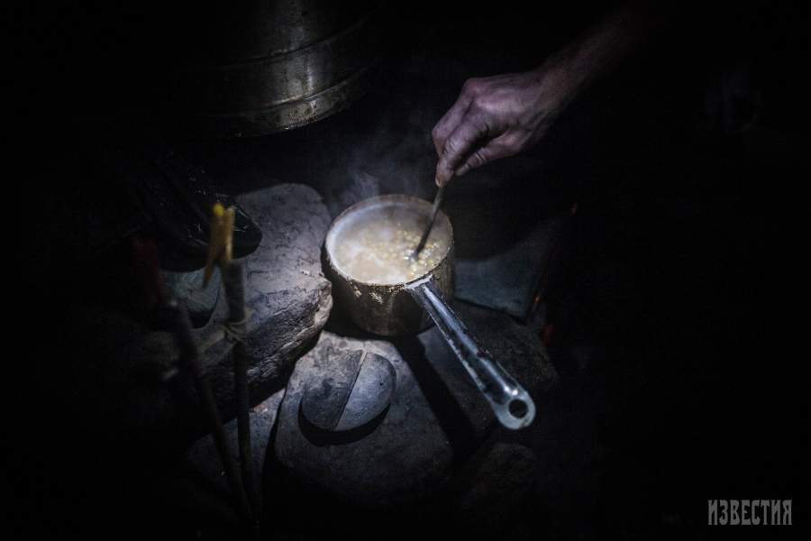 Юрий готовит гороховую каше на печке