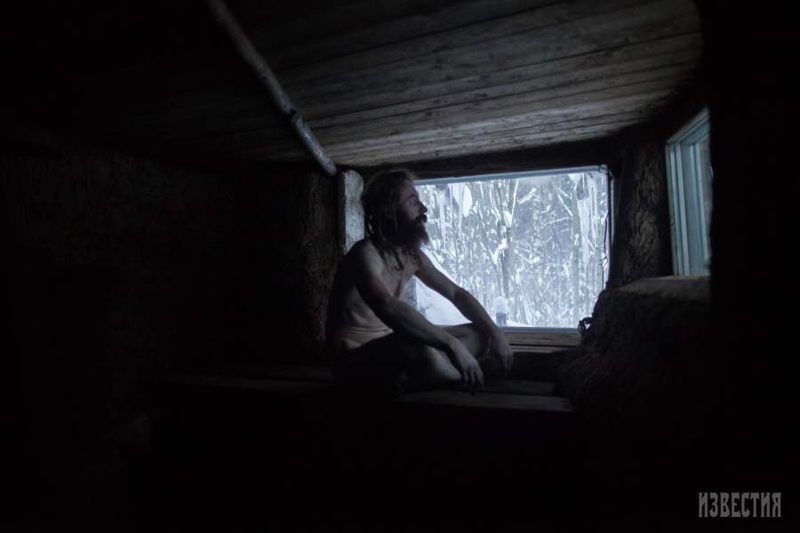 Юрий сидит в натопленной самодельной бане у себя в землянке 