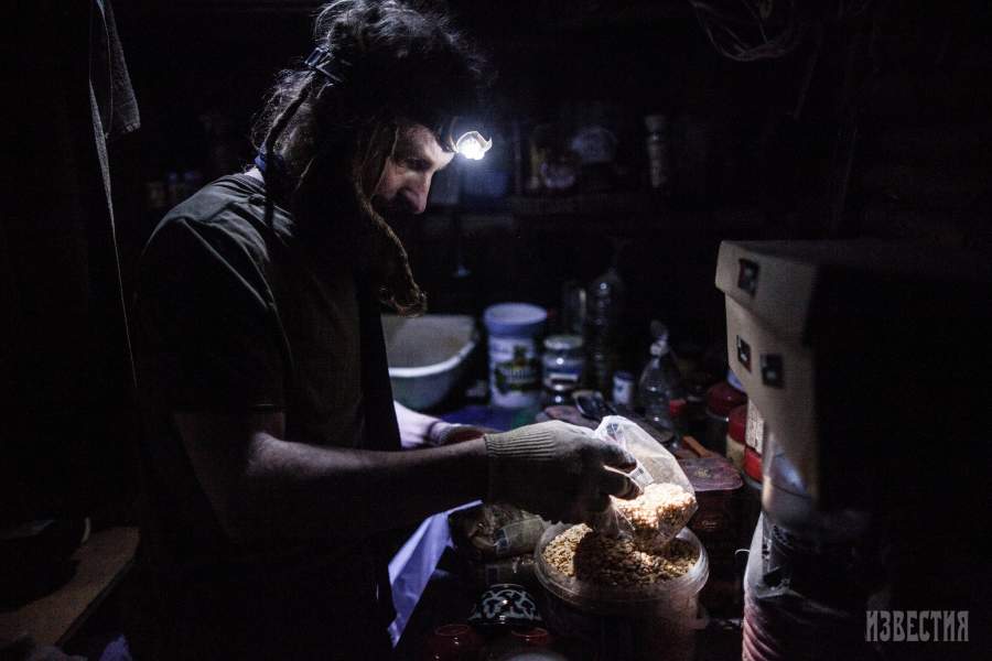 Юрий на самодельной кухне готовит еду (гороховую кашу, которую будет варить на печке)