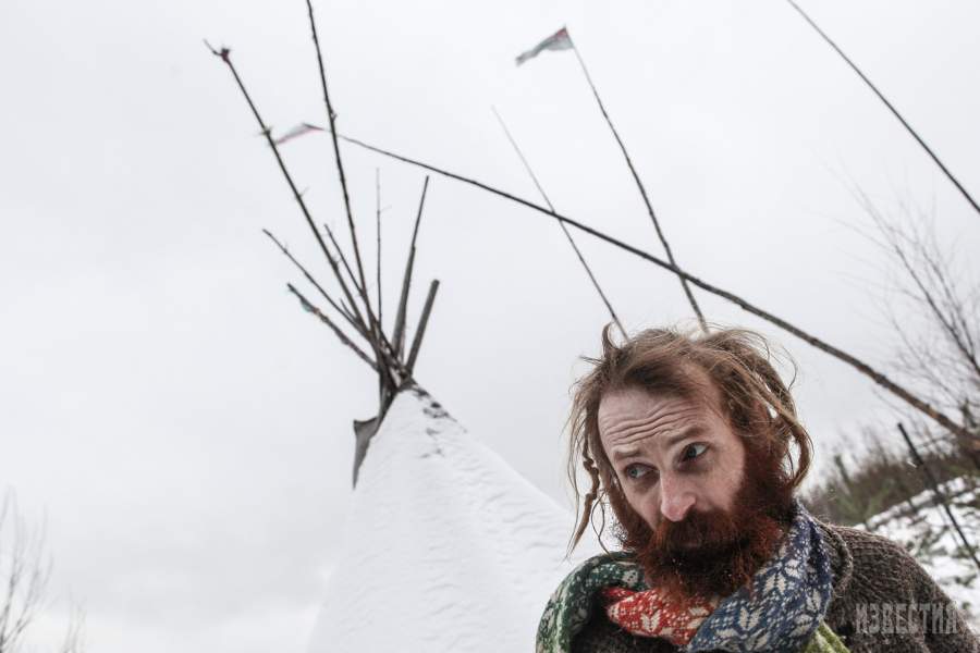 Юрий на фоне самодельной типи (Ти́пи (англ. tipi, tepee, teepee) — повсеместно принятое название для традиционного переносного жилища кочевых индейцев Великих равнин. ) в которой он хранит какие-то вещи