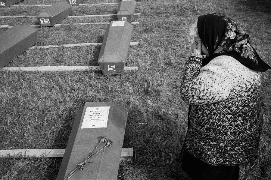 Нина Михайловна Гицарева, дочь Ивана Дмитриевича Михалева (1905 года рождения) плачет над гробом с его останками во время церемонии прощания и захоронения без вести пропавших солдат. Красноармеец Михалев  считался без вести пропавшим в период боевых действий в июне-августе 1942 года. Его останки были найдены поисковым отрядом «Пионер» в поле в районе Белькова, недалеко от Ржева. Опознали его благодаря найденному смертному медальону с его данными.  Кокошкино, Тверская область