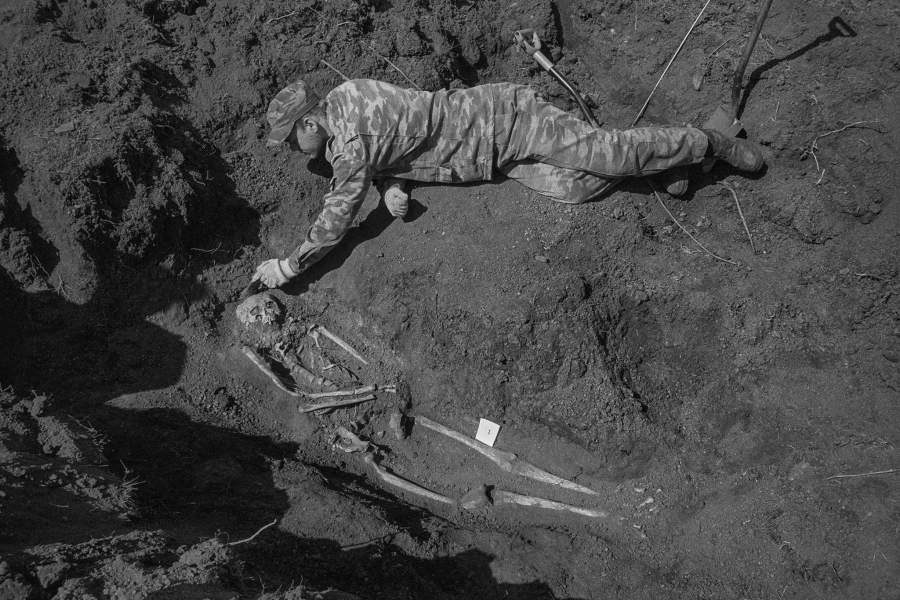 Поисковик очищает останки найденного красноармейца. При постепенной раскопке останков становится понятно, как лежит солдат и от чего он погиб. Подгорное, Северная Осетия