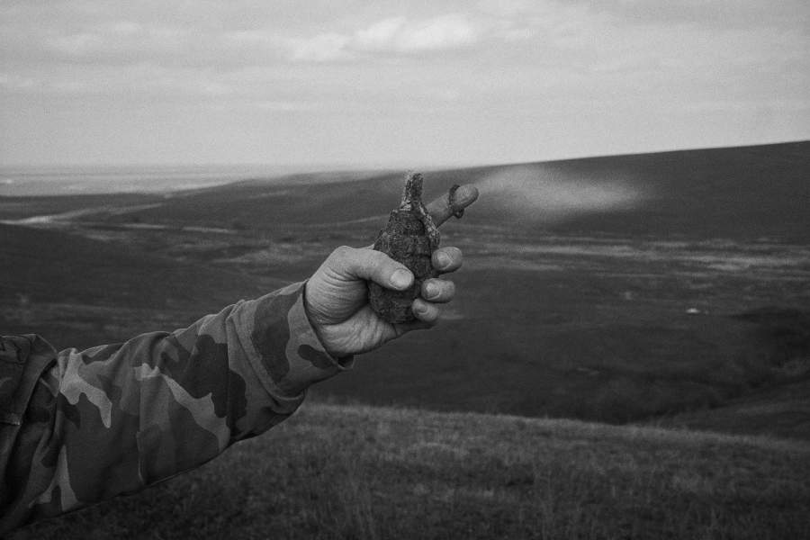 Поисковик держит в руках неразорвавшуюся гранату времен войны, найденную во время поисков на Кавказе. Чаще всего поисковикам попадаются металлические предметы: гранаты, пули, осколки снарядов или мины. Часто бывает, что эти снаряды неразорвавшиеся, поэтому работа поисковика довольно опасная, р-н Подгорного, Северная Осетия