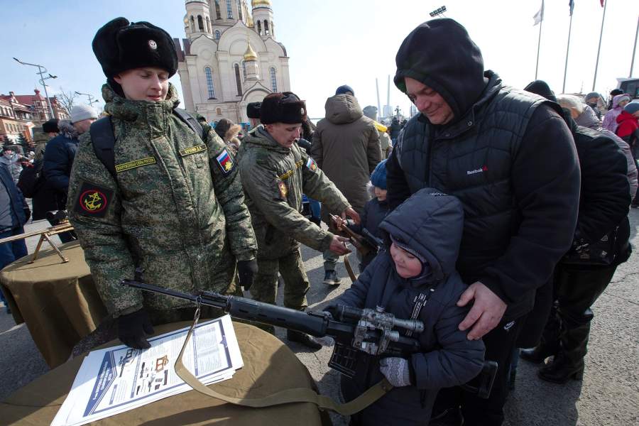 Горожане на выставке оружия во время празднования Дня защитника Отечества на центральной площади во Владивостоке. На первом плане — специальная бесшумная снайперская винтовка ВСС (6П29)