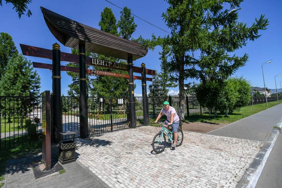 Велосипедист едет мимо закрытого на время действия локдауна парка «Центр Азии» в Кызыле