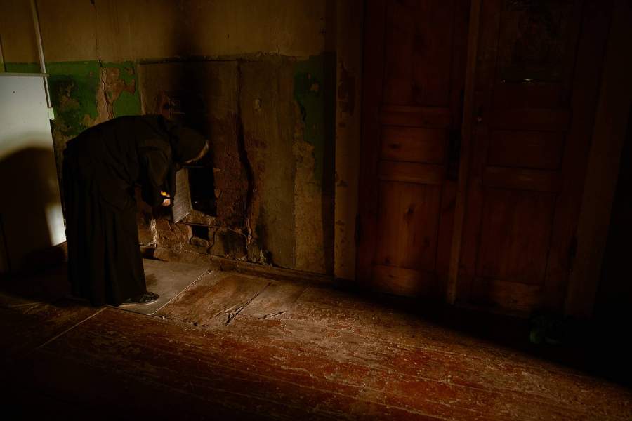 Матушка Неонила показывает старинную печь. Печь коптит, дым выходит в помещение, требуется ремонт