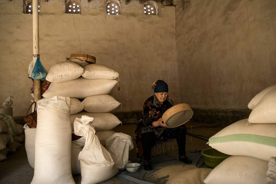 Продавщица риса в Самарканде просеивает его от шлака