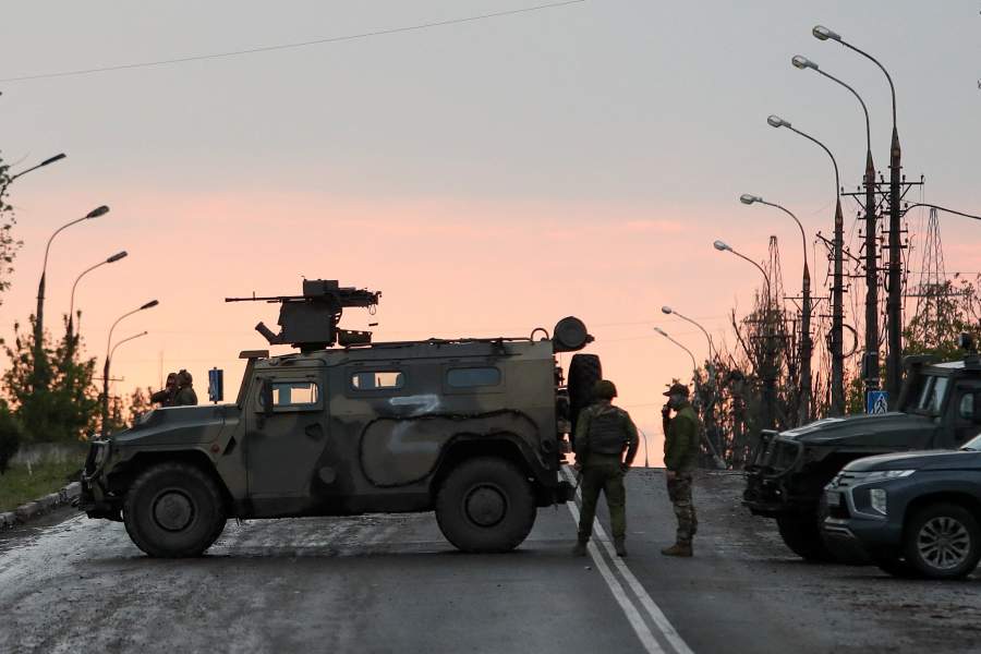 Service members of pro-Russian troops stand guard before the expected departure of Ukrainian soldiers, who surrendered at the besieged Azovstal steel mill, in the course of Ukraine-Russia conflict in Mariupol