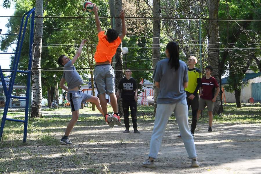 Молодые люди играют в волейбол