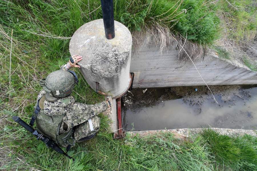 Военнослужащий ВС РФ открывает шлюз по которому будет поступать вода из Северо-Крымского канала в водохранилище завода «Крымский титан»