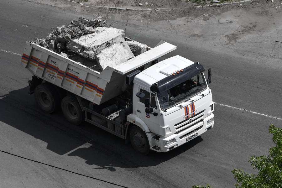 Автомобиль МЧС РФ везет обломки разрушенного здания