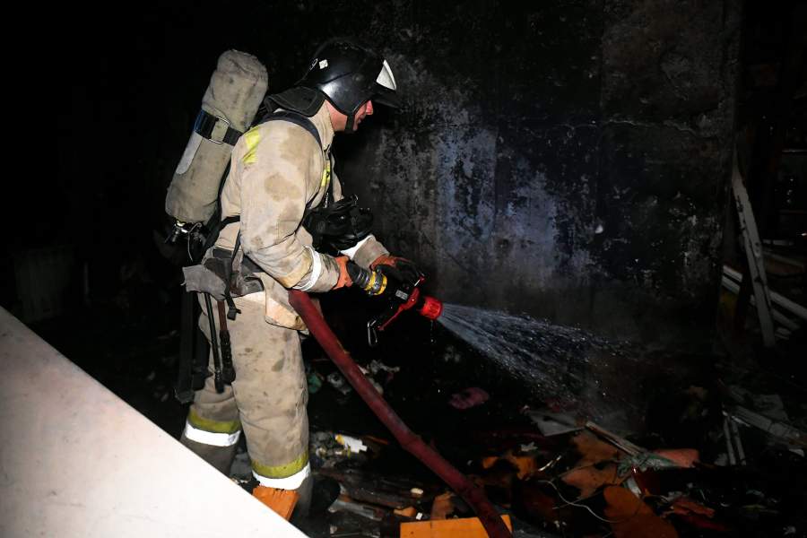 Сотрудники МЧС во время тушения пожара в доме, пострадавшем от обстрела ВСУ в Донецке