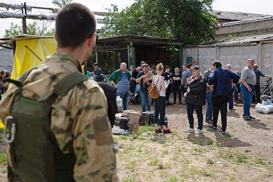 Украина. Луганская область. Северодонецк. Командир батальона территориальной обороны Народной милиции ЛНР с позывным "Белый" и мирные жители во время эвакуации с территории завода "Азот". Эвакуация стала возможной после того, как территория предприятия полностью перешла под контроль сил ЛНР и России. В ответ на обращение руководителей республик Донбасса с просьбой о помощи Вооруженные силы РФ проводят специальную военную операцию на Украине