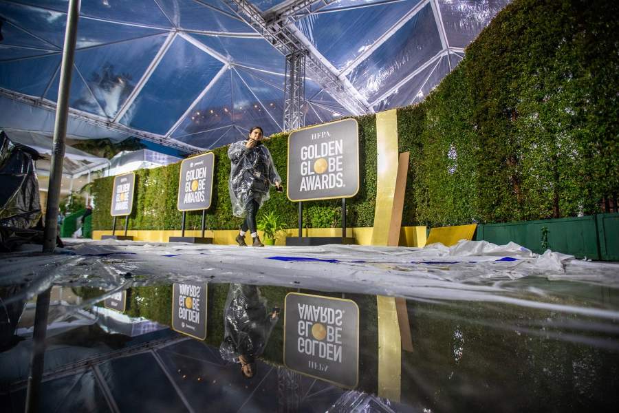 Amidst rain showers, crews are reflected in pools of water as they set up the red carpet for the 80th Golden Globe Awards at The Beverly Hilton