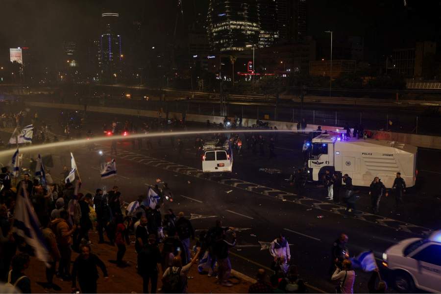 Members of the security forces use a water cannon to disperse the people attending a demonstration after Israeli Prime Minister Benjamin Netanyahu dismissed the defense minister and his nationalist coalition government presses on with its judicial overhaul, in Tel Aviv
