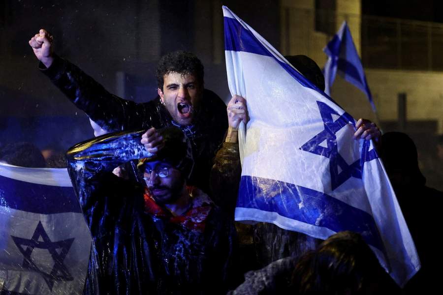 People attend a demonstration after Israeli Prime Minister Benjamin Netanyahu dismissed the defense minister and his nationalist coalition government presses on with its judicial overhaul, in Jerusalem
