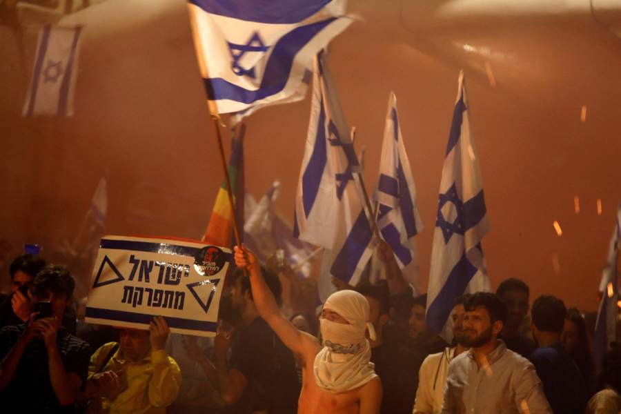 People attend a demonstration after Israeli Prime Minister Benjamin Netanyahu dismissed the defense minister and his nationalist coalition government presses on with its judicial overhaul, in Tel Aviv,