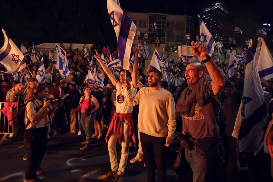 People attend a demonstration after Israeli Prime Minister Benjamin Netanyahu dismissed the defense minister and his nationalist coalition government presses on with its judicial overhaul, in Tel Aviv,