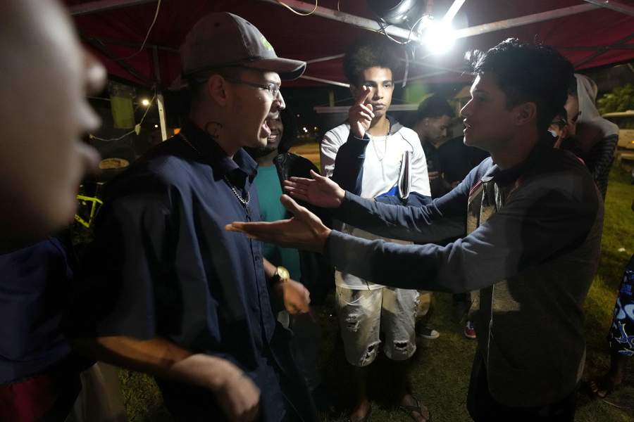 MCs perform during the Battle of MCs from 02, an open-air rap battle in the Sol Nascente favela of Brasilia, Brazil, Wednesday, March 22, 2023. The growth of Sol Nascente, which means Rising Sun, reflects people moving here in search of cheap or unoccupied land to build homes, whereas elsewhere in the Federal District poor people often pay relatively high rents