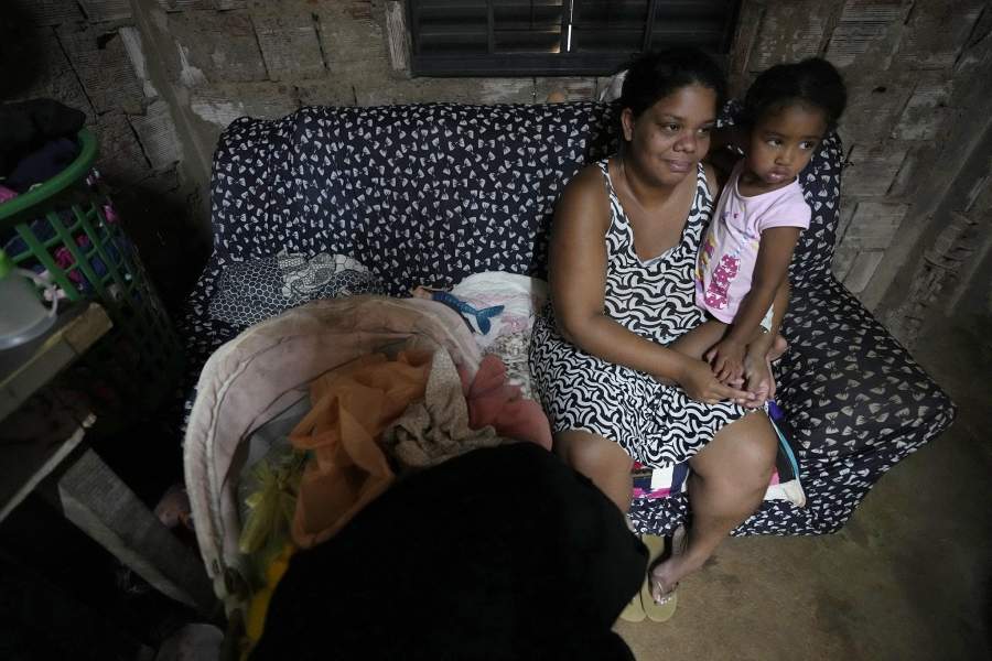 Nayara Miguel and her daughter sit inside their home in the Sol Nascente favela of Brasilia, Brazil, Wednesday, March 22, 2023. Miguel is a housewife with two kids in an area of Sol Nascente that now has electricity and water, and where the local government recently paved streets and installed public lighting