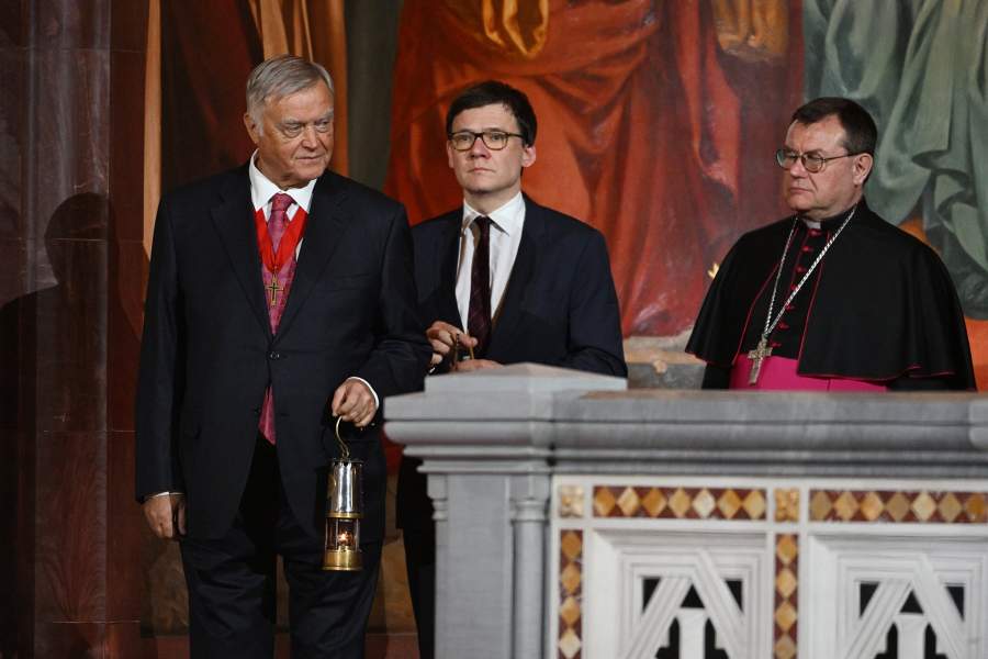 Председатель попечительского совета Фонда Андрея Первозванного Владимир Якунин вносит лампаду с частицей Благодатного огня в храм Христа Спасителя во время пасхального богослужения. Справа: председатель Конференции католических епископов России, митрополит архиепархии Божией Матери в Москве архиепископ Паоло (Павел) Пецци