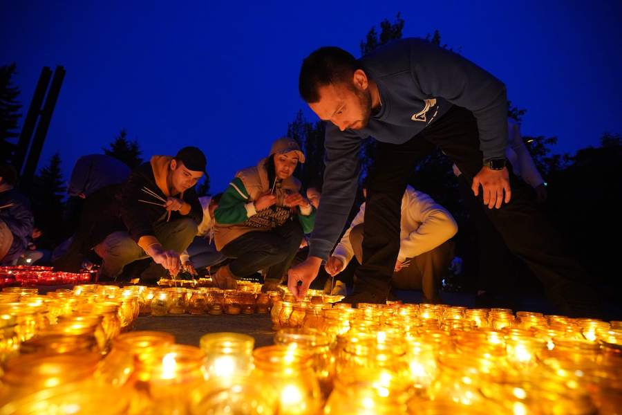 Участники акции «Свеча памяти» зажигают лампады у мемориала у шурфа шахты № 4/4-бис в Донецке. Акция прошла накануне ночью