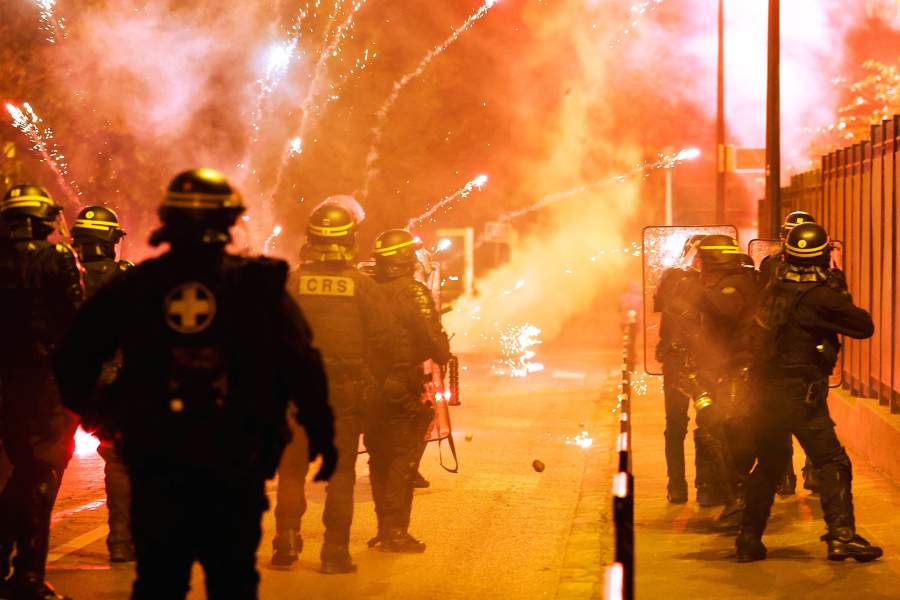 French police stand in position as fireworks go off during clashes with youth, after the death of Nahel, a 17-year-old teenager killed by a French police officer during a traffic stop, in Nanterre, Paris suburb, France, June 30, 2023.