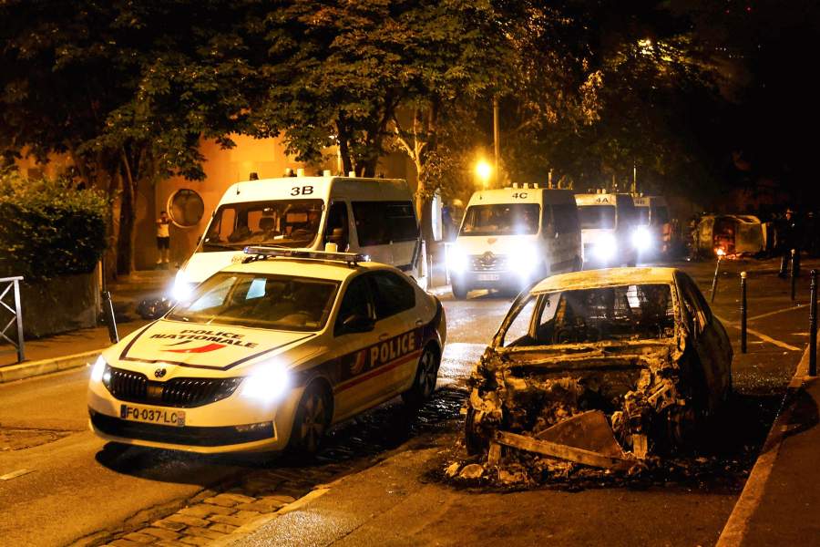 A burned car is seen next to a police vehicle during clashes between protesters and police, following the death of Nahel, a 17-year-old teenager killed by a French police officer during a traffic stop, in Nanterre, Paris suburb, France, June 30, 2023.