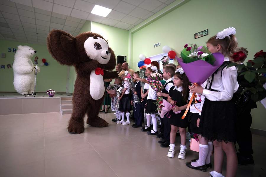Аниматоры и школьники на торжественной линейке, посвященной началу учебного года, в школе № 9 в Мариуполе.
