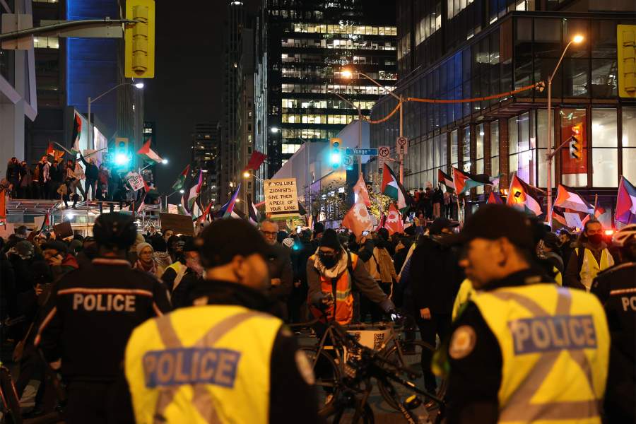 Полиция Торонто стоит на страже, когда сотни людей собираются возле генерального консульства Израиля в Торонто, Онтарио, чтобы продемонстрировать солидарность с палестинцами в секторе Газа и осудить недавние действия правительства Израиля